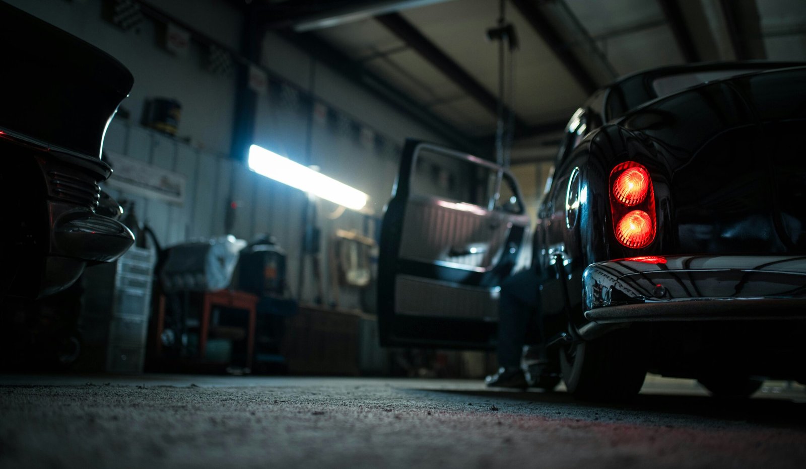 Rear bodywork of a dark car inside a workshop